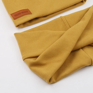 Detail of ginger knit baby hat and neck warmer set with handmade leather label