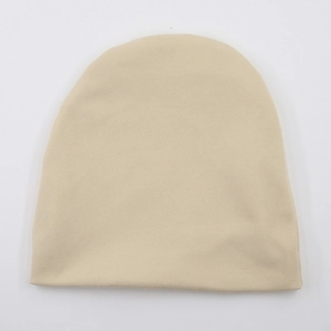 Detailed top view of beige knitted baby beanie showing fine stitching texture and soft fabric