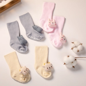 Détail des semelles antidérapantes et poupées 3D sur chaussettes bébé en coton