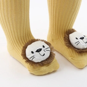 Gros plan sur chaussette bébé jaune avec tête de lion 3D et maille côtelée douce