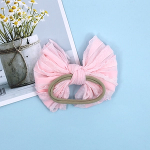Bandeau bébé rose avec nœud en dentelle et élastique en nylon vert sur fond bleu clair