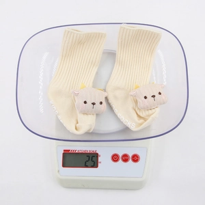 Chaussettes d'hiver pour bébé avec décor d'animaux 3D sur une balance de cuisine