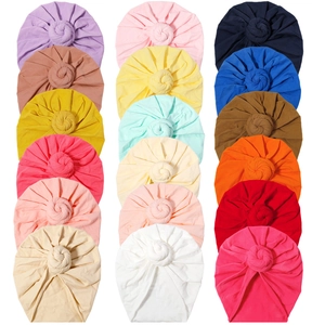 Grid display of eighteen colorful baby turbans featuring stylish donut knot designs