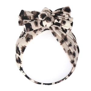 Détail d'un turban en coton pour bébé avec imprimé léopard et double nœud papillon élastique