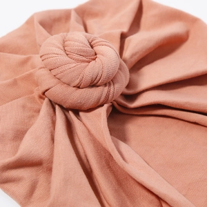 Chic solid color cotton baby turban hat featuring a stylish large twisted knot design