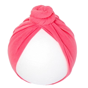 Detail of soft ribbed knit baby turban hat in deep pink with a top donut knot