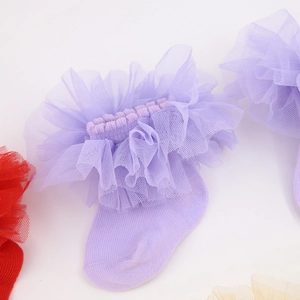 Détail de la dentelle lavande et de la maille douce sur les chaussettes pour filles