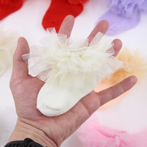 Vue détaillée des chaussettes en coton pour bébé avec dentelle et volants en maille