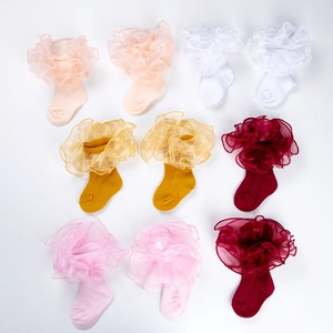 Vue à plat de chaussettes bébé en coton avec de grands volants en tulle de diverses couleurs