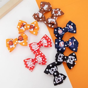 Close-up of sports themed bow hair clips with basketball, football and soccer patterns