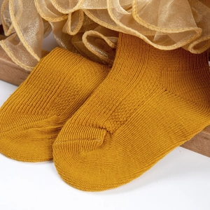 Gros plan de chaussettes en coton jaune moutarde avec bordure en dentelle mesh