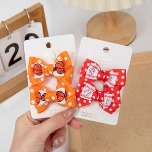 Detail showing handmade sports themed hair clips with basketball and baseball bow designs