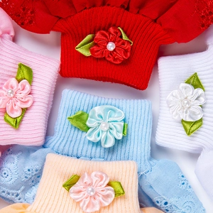 Details von Baby-Baumwollsocken mit handgefertigten Satinblumen und Perlenverzierung