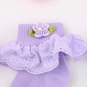 Detailansicht der Baby-Baumwollsocken mit lila Spitze und handgefertigter Blume