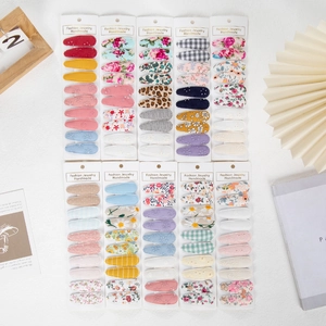 Detailed set of 10 floral and embroidered fabric covered snap clips on display card