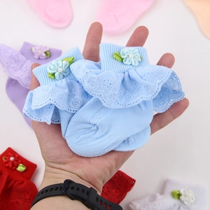 Detailansicht der Baby-Spitzensocken mit Satinblumen und Kunstperlen in Hellblau