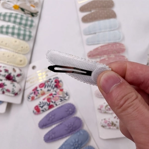 Detail showing the fabric-wrapped metal clip back and fine handmade sealing process