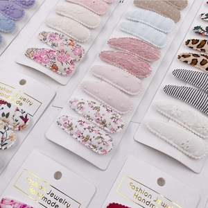 Detailed set of floral and lace fabric hair clips on white handmade display cards