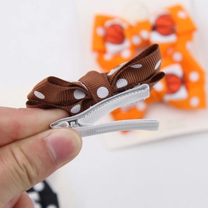 Brown polka dot bow hair clip made of grosgrain ribbon with silver metal duckbill clip