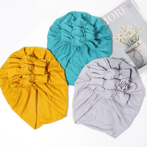 Vue détaillée de bonnets turban pour bébé en maille douce avec nœuds à triple épaisseur