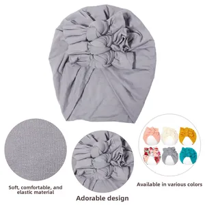 Détail du bonnet turban gris pour bébé avec design à nœuds et tissu en maille élastique