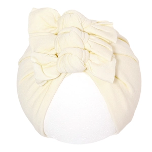 Détail d'un bonnet turban beige pour bébé en tricot côtelé avec triple nœud sur mannequin