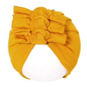 Détail du turban pour bébé jaune gingembre avec trois nœuds en tissu de coton doux
