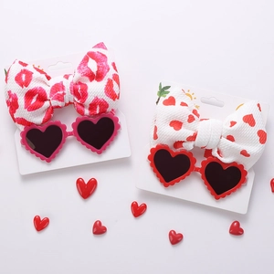 Dettaglio di occhiali da sole a cuore per bambini e set di fasce abbinate su cartoncino