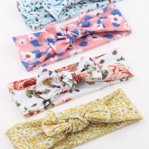 Detail von vier verschiedenen floralen Baby-Stirnbändern mit elastischem Stoff und Knoten