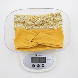 Detailansicht des 2-teiligen Baby-Stirnband-Sets mit Gewicht von 35,9g auf der Waage