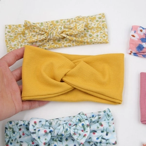 Detail von hochelastischen Baby-Stirnbändern aus Rippstrick in Floral- und Senfgelb