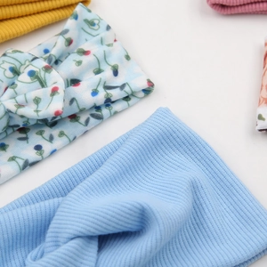 Detailaufnahme von gestrickten Baby-Stirnbändern mit Rippmuster und Blumenprint