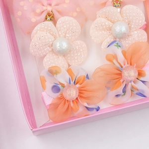 Nahaufnahme von rosa Chiffon-Blumen-Haarspangen und Schleifen-Set in Geschenkbox