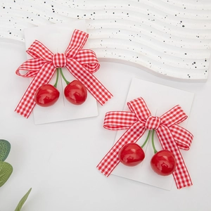 Detail shot of cherry bow hair clips with red and white plaid ribbon and 3D cherry pendants