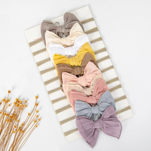 Lot de dix bandeaux bébé en coton et lin colorés sur cartes blanches avec décor floral