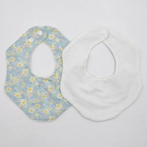 Dettaglio set bavaglini neonato con motivo floreale e trama in spugna assorbente