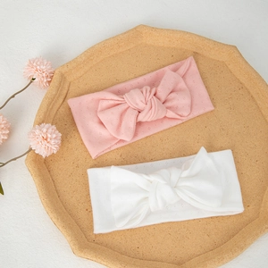 Detailed view of pink and white organic cotton bow headbands with breathable knit pattern