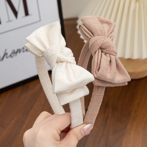 Close-up of dual-layer striped cotton bow headbands in cream and lavender purple colors