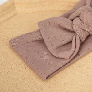 Detail of baby headband with a center knot in dusty pink cotton pointelle fabric