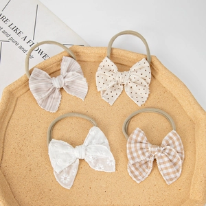 Set of four infant headbands with cotton lace and checkered bows on nude nylon bands