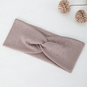 Detail of cross-twist knitted yoga headband in mauve with breathable dot pattern texture