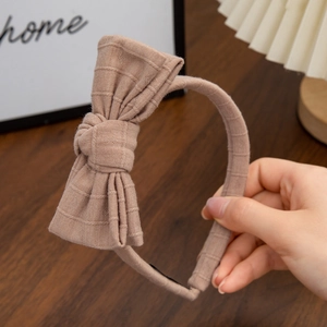 Detail of coffee brown cotton bow headband with waffle texture and knitted fabric