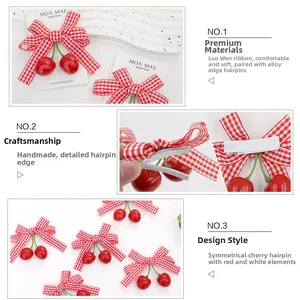 Detail of red gingham bow hair clips with cherry charms and handmade fabric edges