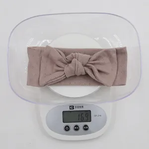 Detail shot of organic cotton baby headband in dusty rose showing weight of 16.9g