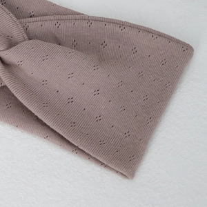 Detail of mauve pointelle knit yoga headband showing breathable diamond pattern texture