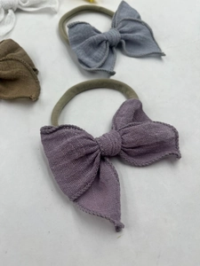Détail de bandeaux de bébé en gaze respirante multicolore avec nœuds sur fond blanc
