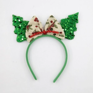 Cerchietto di Natale con alberi di paillettes e fiocco di agrifoglio su sfondo bianco