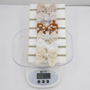 Detailed weight display of 6-piece baby bow headbands set showing 43.4g on a digital scale