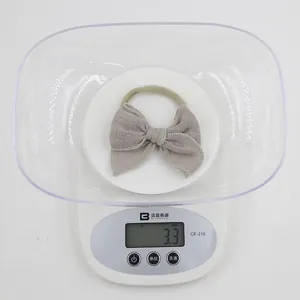 Détail d'un bandeau en tissu gris avec bords ondulés pesant 3,3 g sur une balance