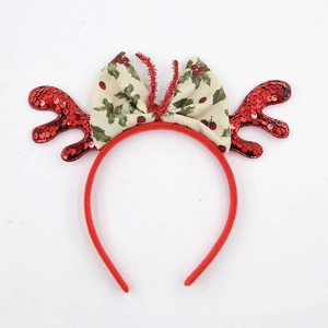 Dettaglio di corna di renna con paillettes rosse e fiocco festivo su un cerchietto